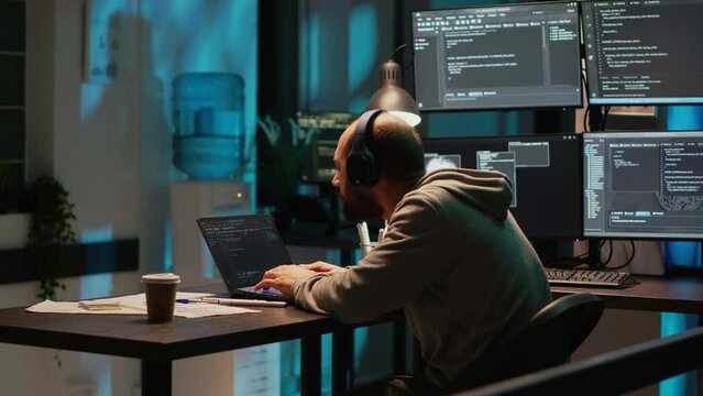 Silly web developer playing air drums and listening to music on headset, enjoying song and working on new user interface programming. Male coder having fun fooling around and acting careless.