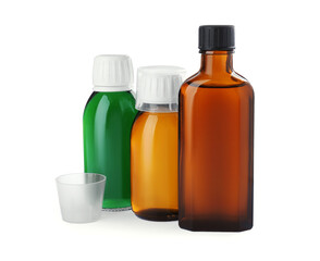 Bottles of syrups with measuring cups on white background. Cough and cold medicine