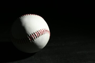 Baseball ball on black background, space for text. Sports game