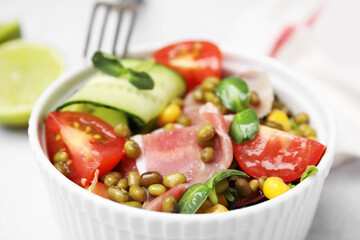 Bowl of salad with mung beans on white table, closeup