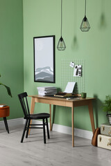 Typewriter, stack of papers and mood board on wooden table near pale green wall. Writer's workplace