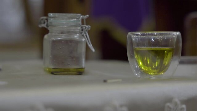 Aceite sacramental en recipiente de vidrio para bautismo.