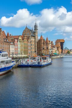 Vertical shot of the beautiful old town buildings and water trams at the river in Gdansk, Poland