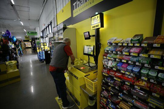 Senior man using the self-checkout kiosk at Dollar General