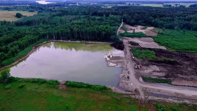 high drone images with a view of a sand and gravel mine next to a large lake in Latvia. wide view
