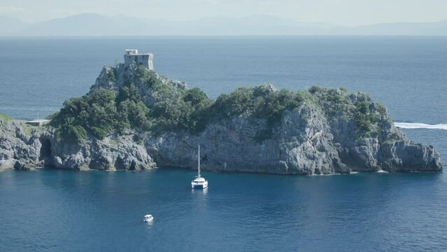 Boats Anchored Near Torre del Capo di Conca, Ancient Watchtower On A Promontory In The Middle Of Sea. Historical Landmark In Conca dei Marini, Italy. wide