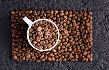 Roasted coffee beans in a cup, on dark background, close-up image, space for text