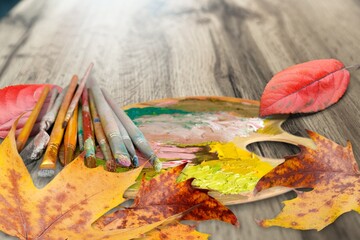 Obraz premium Dry autumn leaves and drawing paint palette