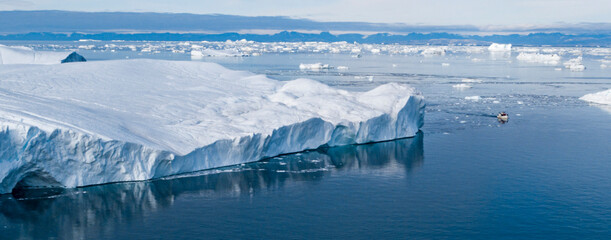 Climate Change and Global Warming. Icebergs from melting glacier in Ilulissat, Greenland with boat...