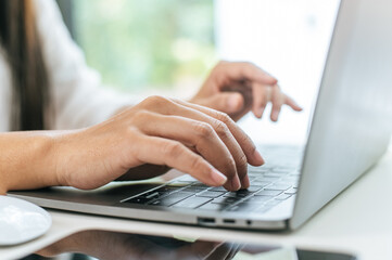 Young woman working on laptop computer in coffee shop