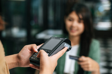 Young businesswoman paying order having contactless payment with cardit card