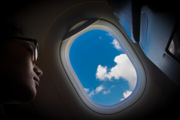 Woman looks out the window of an flying airplane.