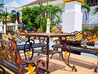 brown gold iron carving bench with arabic architecture in madiun indonesia park, sunny weather.