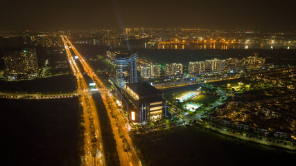 Aerial night view of Bitexco Tower, buildings, roads, Thu Thiem 2 bridge and Saigon river in Ho Chi Minh city - Far away is Landmark 81 skyscraper. Business and landscape concept.