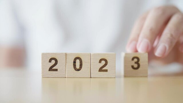 New year 2022 change to 2023. Hand putting wooden cube block with year number. New year resolution, Merry Christmas