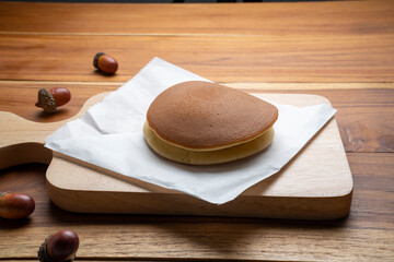 Dorayaki or Japanese pancake wih sweet red bean paste filling, Japanese Bun Sweet-Filled Pancakes on wooden plate.