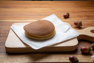 Dorayaki or Japanese pancake wih sweet red bean paste filling, Japanese Bun Sweet-Filled Pancakes on wooden plate.