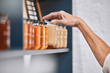 Honey, product and retail with hands of woman for natural, supermarket and grocery shopping shelf. Food, health and sustainability with organic store employee for small business, sale and choice