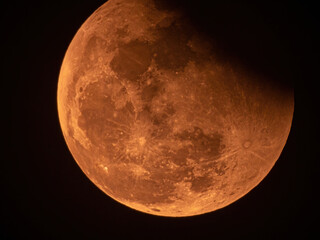 Real full blood moon, half moon in black sky with cloud