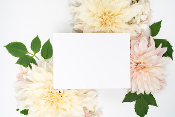 White and blush fresh dahlia blooms and blank stationery card flat lay