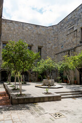 Fototapeta na wymiar fountain inside old stone house surrounded by greenery, central courtyard, latin america