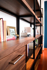 metal and wood bookcase, with drawers person in front passing
