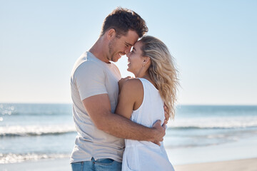 Couple, love and hug in relationship at the beach for summer vacation or romantic bonding in the outdoors. Happy man and woman hugging with smile together in loving embrace for romance by the ocean