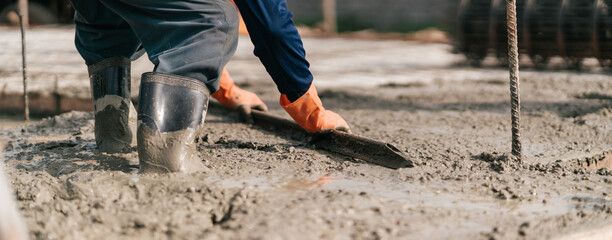 Selective focus, Construction worker pouring cement and concrete. Worker leveling concrete floor...