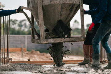 Construction building worker pouring concrete floor of buildings in construction site. Pouring concrete slab.
