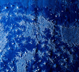 White snowflakes on a blue metal sheet.