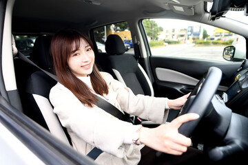 Fototapeta na wymiar 笑顔で運転をする若いアジア人女性
