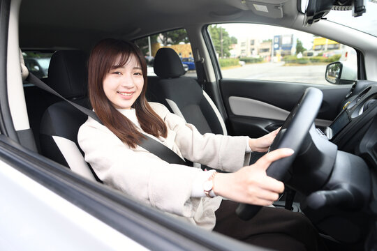 笑顔で運転をする若いアジア人女性