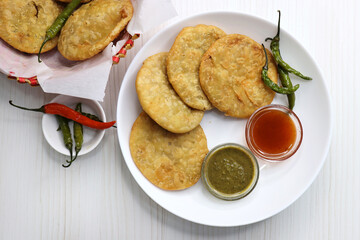 Shegaon Kachori or aloo pyaz ki kachodi served with green and red Chutney. Fried green chilies. it's a favorite Tea time snack, stuffed with lentils and spices mixture inside the dough. Deep fried.  - obrazy, fototapety, plakaty