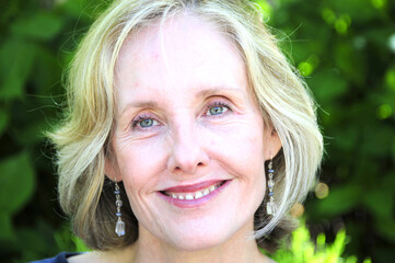Mature female blond beauty expressions outdoors.