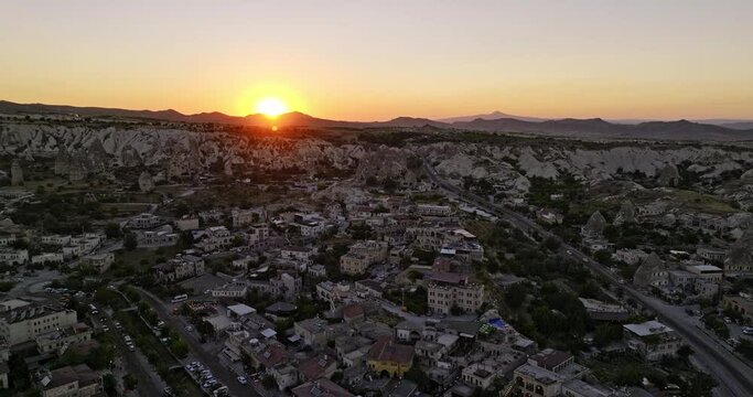G&ouml;reme Turkey Aerial v32 reverse flyover old village capturing traffics across ancient cave town on major streets with golden sun setting below the horizon - Shot with Mavic 3 Cine - July 2022