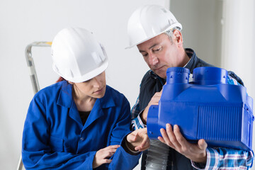 two workers in factory on the machine