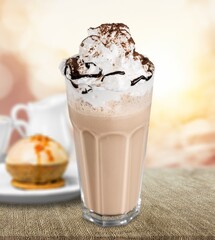 Tasty aroma latte in glass with leaves on the desk