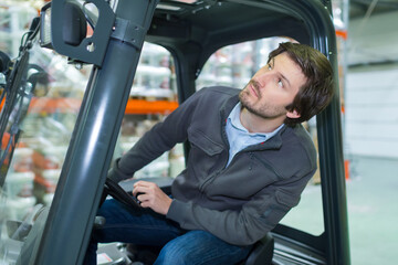 industrial warehouse worker operating forklift