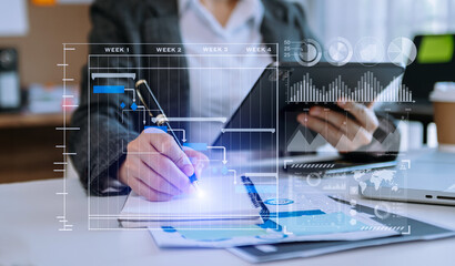 Businessman hand Project manager working and update tasks and Gantt chart scheduling virtual diagram.with smart phone, tablet and laptop in office.