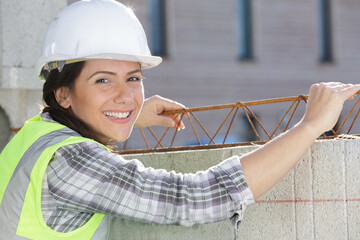 female worker fixing steel rebar on building site