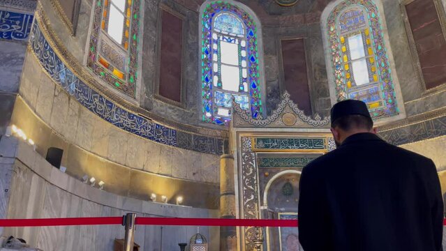 Back of anonymous muslim man praying inside Ayasofya mosque in Istanbul, Turkey