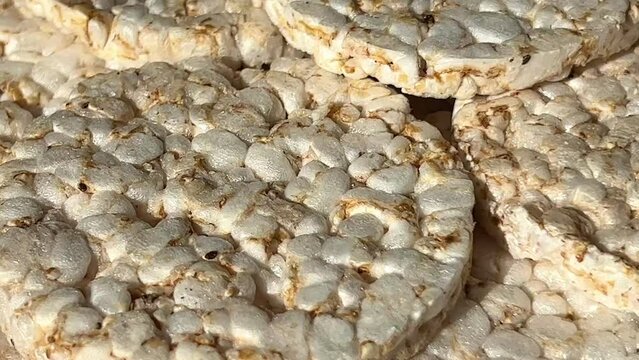 Round crunchy puffed rice cakes on a black background. Close-up. Concept of dietary healthy snack.