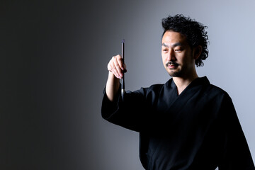 Image like a Japanese calligrapher「shodo」 holding a brush.
