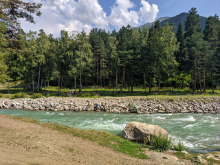 Arkhyz, Karachay-Cherkessia, Russia - August 24, 2022: View of the Zelenchuk River in the village of Arkhyz against the backdrop of the Caucasus Mountains