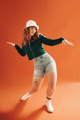 Vibrant young woman doing some dance moves in a studio