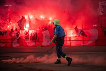 Firefighter with uniform in the Stadium during the soccer event removing torches. Torches and...