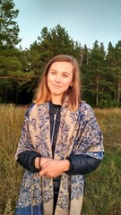 a young girl with short hair stands in the forest