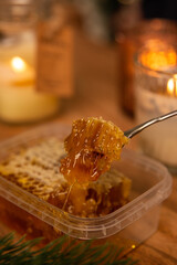 honeycomb in a christmas new year interior on a wooden table with candles around, winter holiday desserts