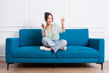 Fototapeta na wymiar image of young Asian girl sitting on sofa at home