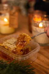 honeycomb in a christmas new year interior on a wooden table with candles around, winter holiday desserts